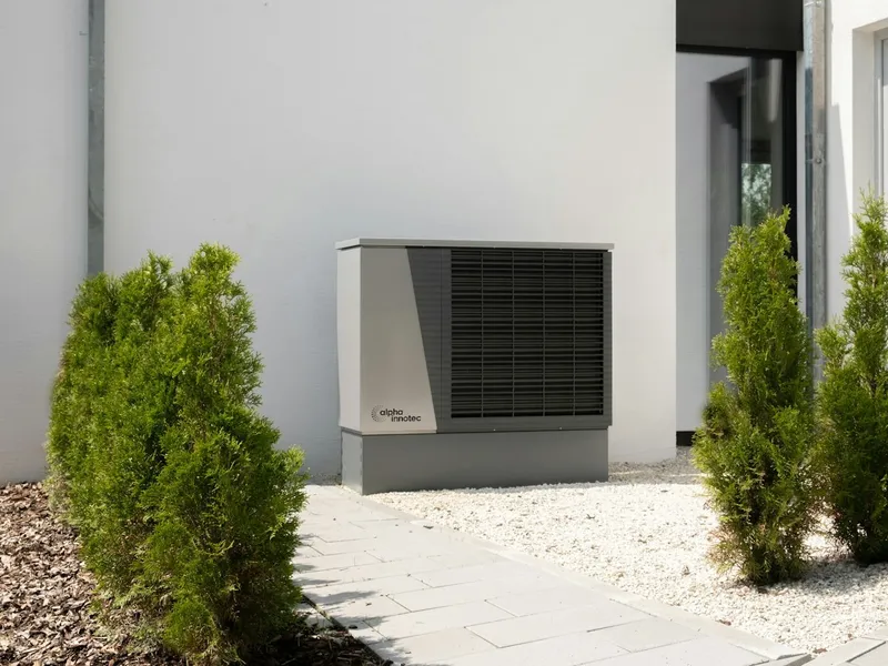 Außengerät einer Klima- und Wärmepumpenanlage vor einer hellen Hauswand