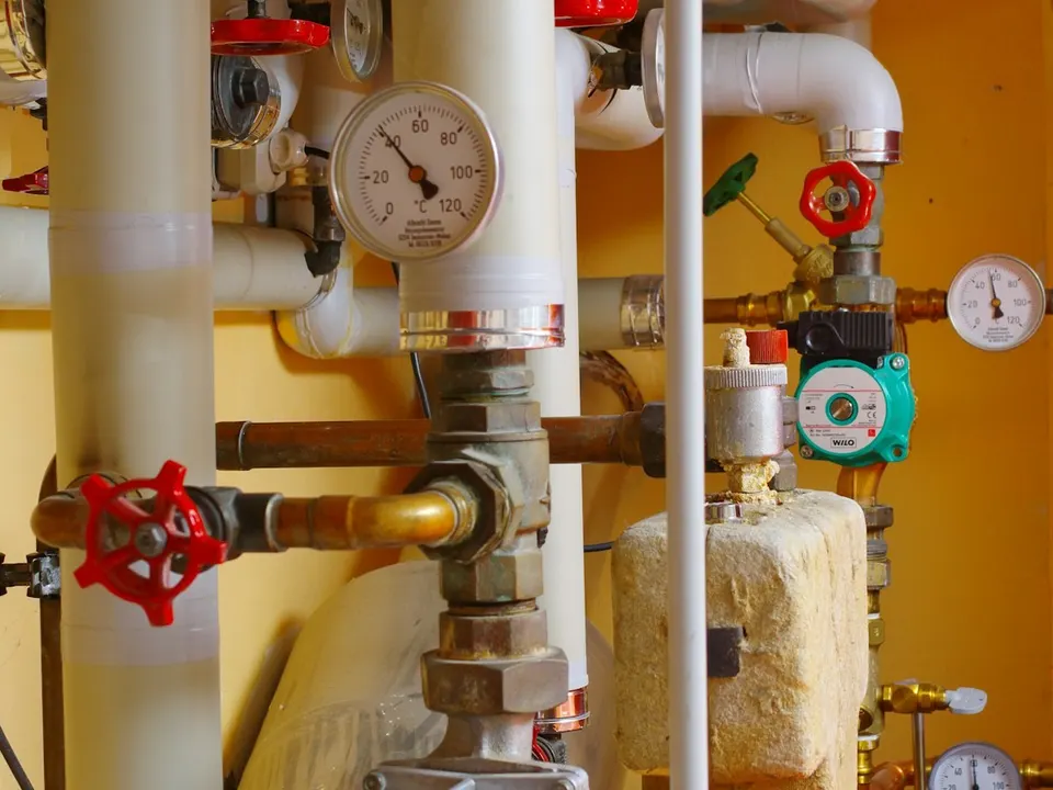 Heizungsarmaturen mit Pumpe und Manometer in einem Heizraum